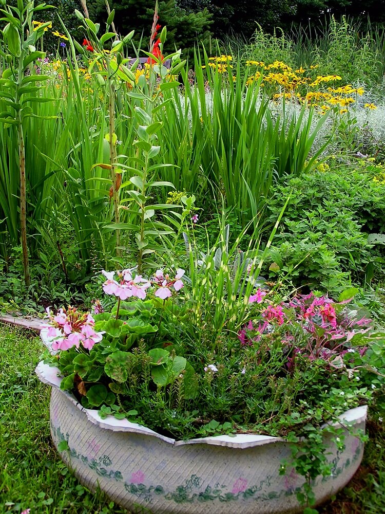 Tire planter with flower design filled with herbs and flowers